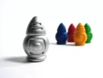 Figurine grise devant quatre objets colorés bleu rouge orange vert